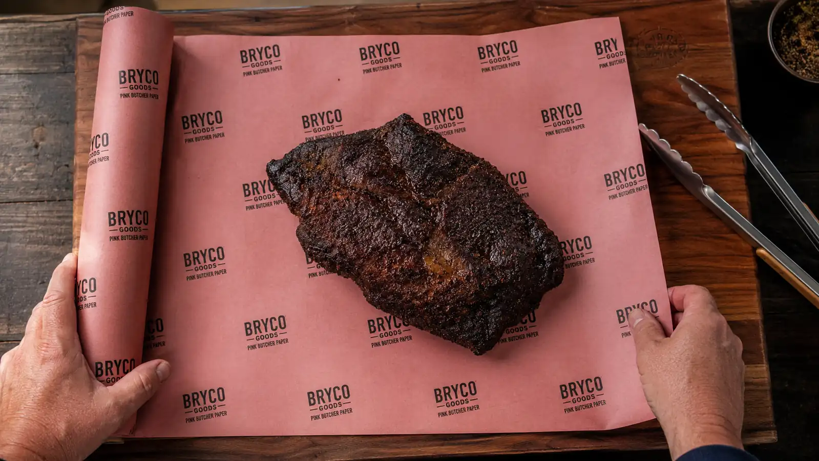 A trimmed brisket resting on butcher paper before wrapping, bark visible and dark