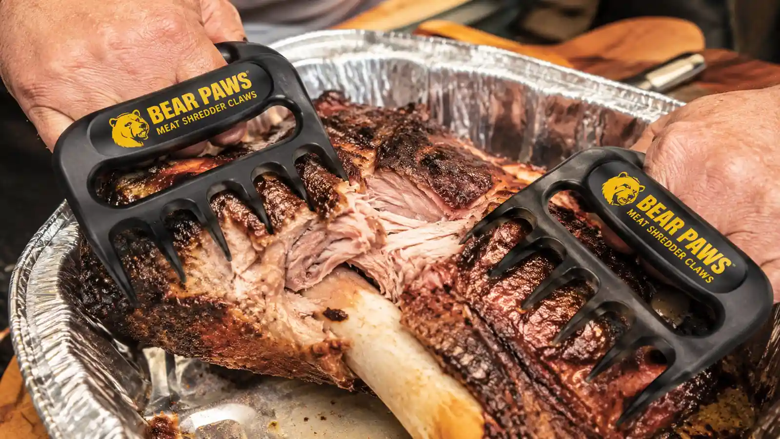 Close-up of Bear Paw meat claws digging into pork shoulder to separate the bone